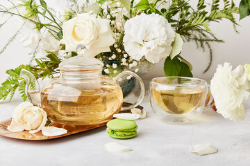 Obraz na płótnie Canvas Herbal green teapot, cup, macaroon dessert, white flowers lifestyle. Aesthetic feminine, meditative time for yourself, cozy home.