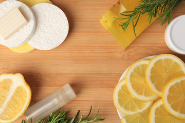 Fototapeta na wymiar Lemon face cleanser. Fresh citrus fruits, rosemary and personal care products on wooden table, flat lay