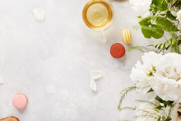 Aesthetic table setting. Herbal green teapot, cup, macaroon dessert, white flowers lifestyle. Aesthetic feminine, meditative time for yourself, cozy home.