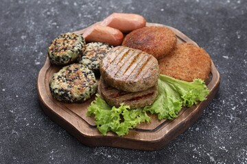 Different tasty vegan meat products on grey table