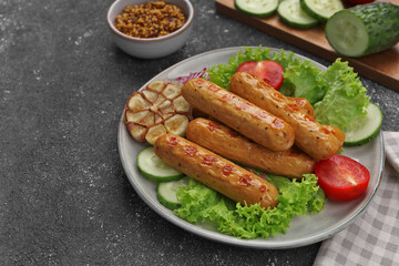 Delicious grilled vegan sausages with fresh herbs and vegetables on grey table, space for text