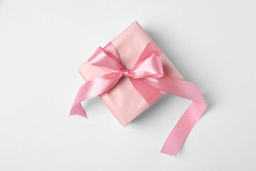 Beautiful gift box with pink bow on white background, top view