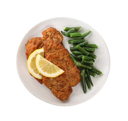 Plate of tasty schnitzels with lemon and green beans isolated on white, top view
