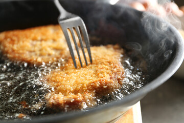 Cooking schnitzels in frying pan, closeup view