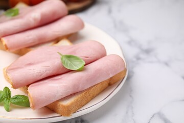 Delicious sandwiches with ham on white table, closeup