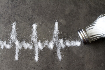 Salt shaker, cardiogram made of salt, hypertension concept 