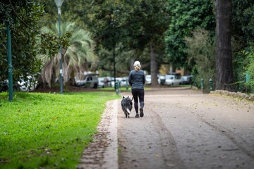 couple walking in a garden. man and woman walk in nature under trees surrounded by plants. family together in a park in spring time