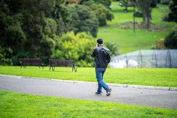 couple walking in a garden. man and woman walk in nature under trees surrounded by plants. family together in a park in spring time