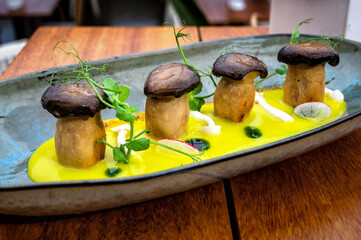 Dish featuring whole mushrooms in a yellow sauce made from cream and mustard.