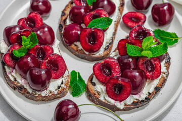 Fresh bread sandwiches with sweet cherry, cream cheese and mint leaves. Morning breakfast concept