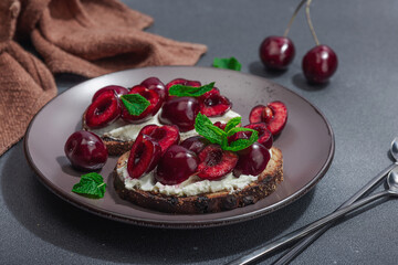 Fresh bread sandwiches with sweet cherry, cream cheese and mint leaves. Morning breakfast concept