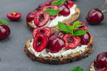 Fresh bread sandwiches with sweet cherry, cream cheese and mint leaves. Morning breakfast concept