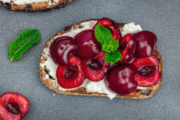 Fresh bread sandwiches with sweet cherry, cream cheese and mint leaves. Morning breakfast concept
