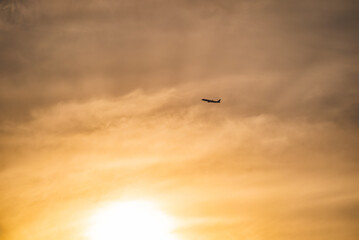 夕暮れ時に離陸して爽快に飛行する飛行機のシルエット