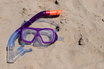 children's diving mask on the sand at the beach