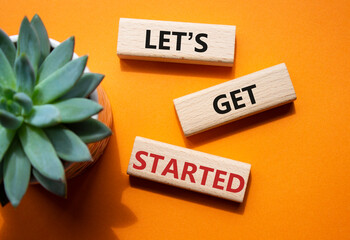 Lets get started symbol. Concept words Lets get started on wooden blocks. Beautiful orange...