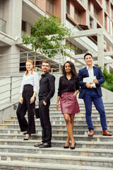 Fototapeta premium Young people, employees, managers standing in office and smiling, City, street background. Success and promotion