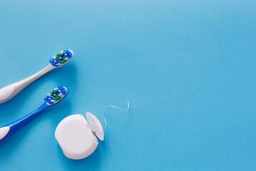 Top view of dental floss and brushes on blue with copy space