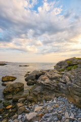 pebble coast at sunrise. gorgeous view of seascape on a cloudy morning. relax and recreation at the sea