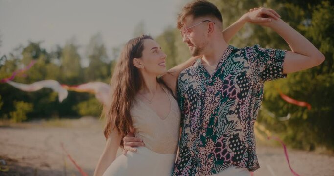 Young couple dancing bachata together at beach on sunny day
