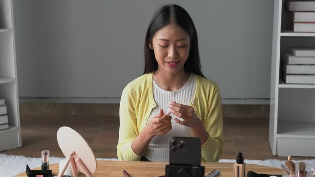 Portrait of young Beauty blogger asian woman review recording video make up lipstic cosmetic at home.