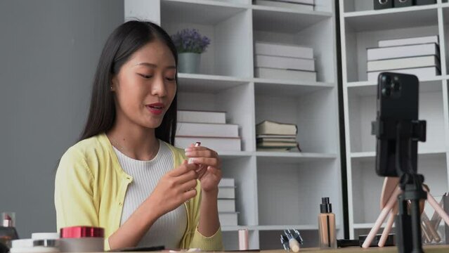 Portrait of young Beauty blogger asian woman review recording video make up lipstic cosmetic at home.