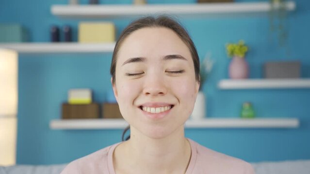 Close-up portrait of satisfied Asian young woman.