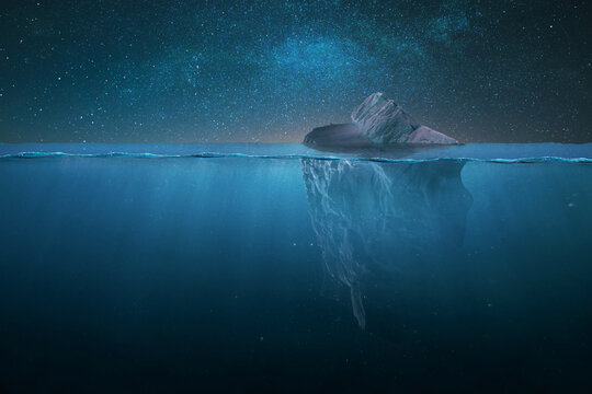 Tip of a drifting iceberg in the water and underwater view on a starry night in the ocean. Global warming and melting glaciers, concept. Danger, creative idea. Iceberg at night