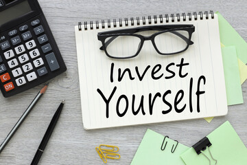 invest in yourself top view of open notepad with text. points on the page.