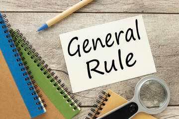 GENERAL RULE page with text next to the notepad. wooden table