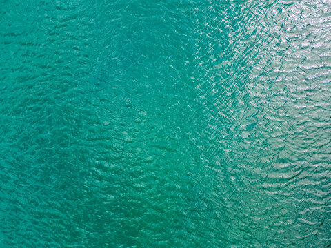 Aerial view of a crystal clear sea water texture. View from above Natural blue background. Blue water reflection. Blue ocean wave. Summer sea. Drone. Top view. High quality photo