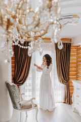 The bride in her stylish room, preparing for the wedding. A girl in a dressing gown