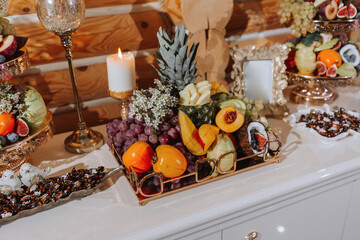 table with various fruit decorations. Watermelon carving, pineapple slices, grapes, orange