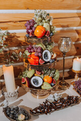 table with various fruit decorations. Watermelon carving, pineapple slices, grapes, orange
