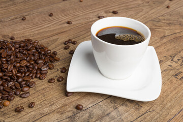 cup of coffee and coffee beans on a wooden table