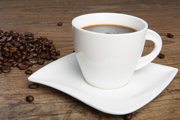 cup of coffee and coffee beans on a wooden table