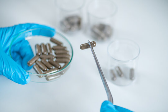 Medical innovation as a scientist meticulously prepares fecal transplant caps in the lab. Witness the dedication and precision behind thisresearch aiming to revolutionize healthcare.