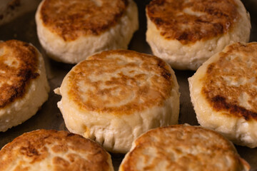 Close-up of cottage cheese cheesecakes fried in a frying pan. The process of cooking delicious homemade food.