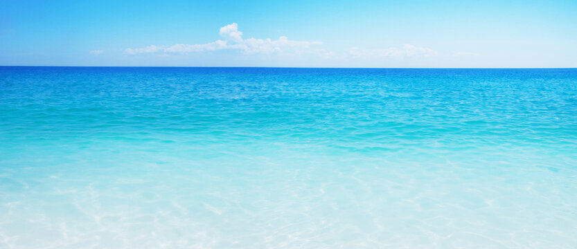 Idyllic sand beach, tranquil sea, and blue sky create a serene summer vacation destination.