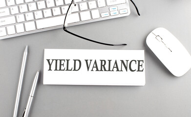 YIELD VARIANCE text on paper with keyboard on grey background