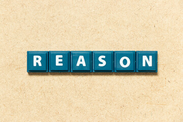 Tile alphabet letter in word reason on wood background