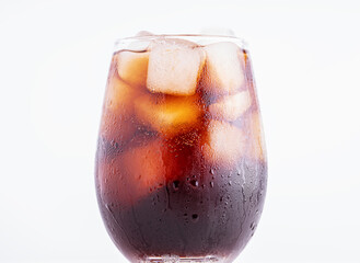 Cola with ice. Fresh cold sweet drink with ice cubes on white background with copy space. Fresh cold sweet drink with ice cubes.