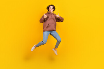 Fototapeta na wymiar Full length photo of overjoyed person jumping demonstrate thumb up isolated on yellow color background