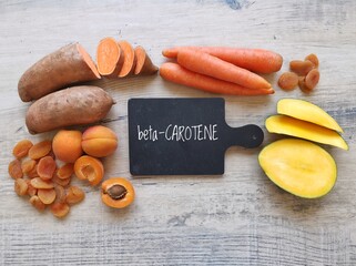 Food rich in beta carotene with text Beta Carotene. Various fruits and vegetables as natural...
