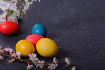 Fototapeta na wymiar Freshly baked homemade Easter bread, natural dyed eggs and spring flowers.