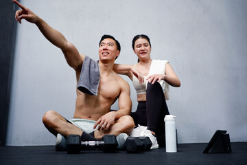 Young man and woman exercising in the gym. happy smile fitness concept.