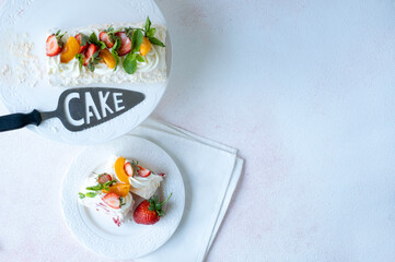 Delicious meringue roll with fruit. strawberries, apricots and mint on a white background.