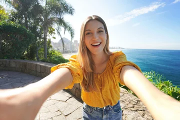 Fotobehang Holidays in Rio de Janeiro, Brazil. Beautiful smiling young woman takes selfie on belvedere terrace in Rio de Janeiro, Brazil. © zigres