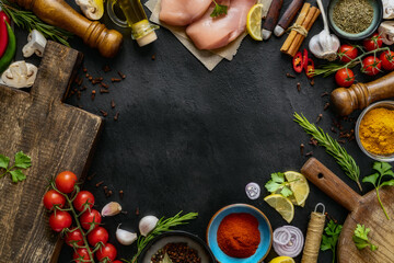 Frame of cooking ingredients background. Various spices, fresh vegetables, herbs, chicken breast...