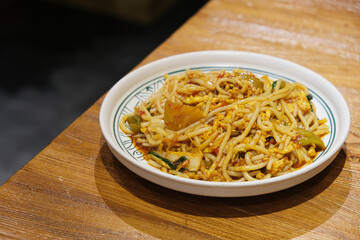 a plate of Yunnan fried rice noodles on dinner table. Chinese food